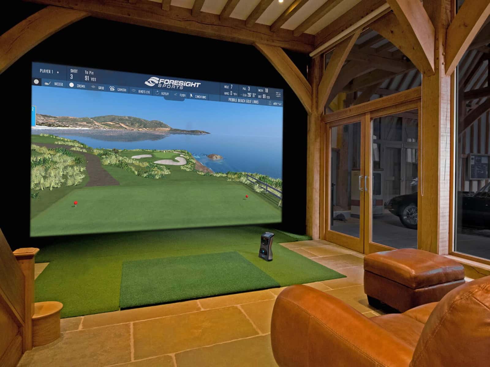 Sample set up of an indoor Foresight golf simulator setup with couch and ottoman