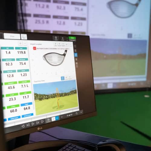 Golf simulator screen displaying ball impact data and trajectory analysis for realistic golf practice and improvement.